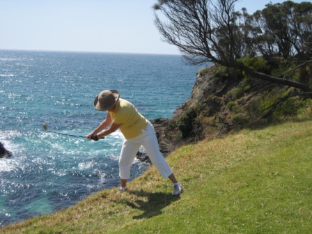 Liz playing next to the water hazard, the Pacific Ocean
